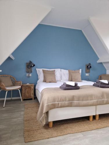 een slaapkamer met een groot bed met een blauwe muur bij Beachhouse Zeewinde in Zoutelande