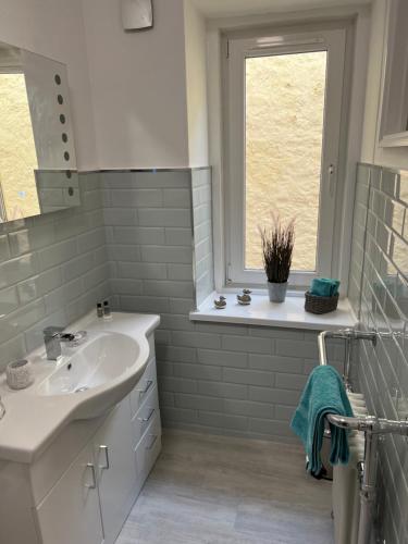 a white bathroom with a sink and a window at Large Three bed Two bathroom flat in Central Torquay in Torquay