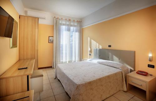 モンテカティーニ・テルメにあるHotel Salusのベッドと窓が備わるホテルルーム