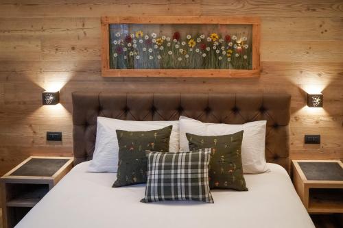 a bedroom with a bed with a painting on the wall at Sci Sport rooms & suites in Bormio
