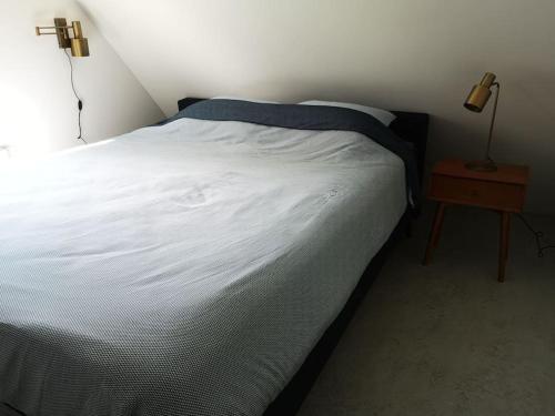 - une chambre avec un lit blanc et une table de nuit dans l'établissement Lanterfant, à Nes