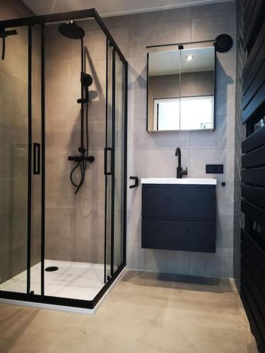 a bathroom with a glass shower and a sink at Lanterfant in Nes