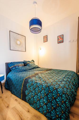 - une chambre avec un lit et une couette bleue dans l'établissement Appartement Emeraude, à Martigues