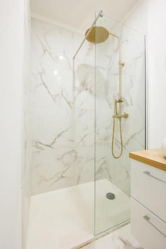 une douche avec une porte vitrée dans une salle de bain dans l'établissement Appartement Emeraude, à Martigues