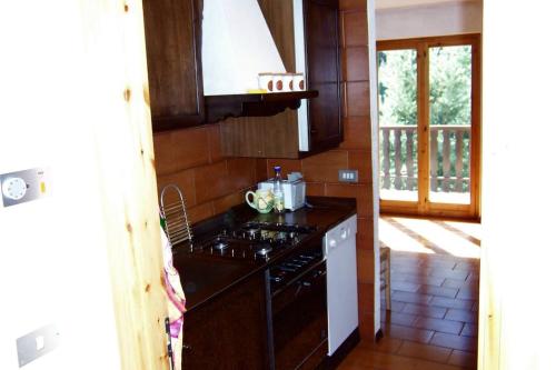 a kitchen with a stove and a stove top oven at Valtournenche Appartamento comodo alle piste in Singlin