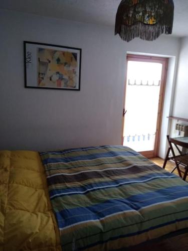 1 dormitorio con 1 cama en una habitación con ventana en Valtournenche Appartamento comodo alle piste en Singlin