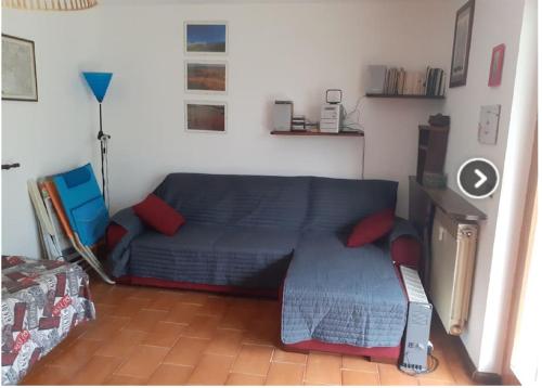 una sala de estar con un sofá azul en una habitación en Valtournenche Appartamento comodo alle piste en Singlin