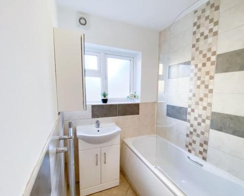 a bathroom with a sink and a bath tub and a sink at Central 4 bed-Reading City Centre in Reading