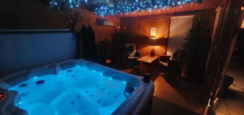 多爾蓋萊的住宿－Cader Suite at PenYcoed Hall incl Luxury Hot Tub，一张桌子,房间里有一个大型蓝色浴缸