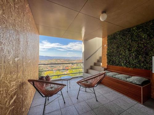 a room with two chairs and a bench with a view at Casas Dona Matilde in Torre de Moncorvo