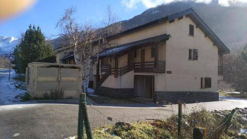 a house with a garage and a mountain at Appartement 4 personnes Porté Puymorens in Porté-Puymorens