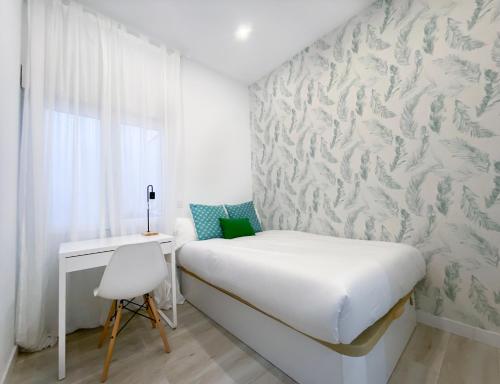 a small bedroom with a bed and a desk at Batuecas Plaza Castilla - 4 dormitorios in Madrid