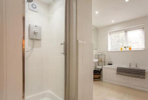 La salle de bains blanche est pourvue d'une douche et d'un lavabo. dans l'établissement Luxury and Stylish one bed apartment in Windsor, à Windsor