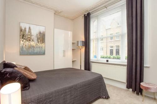 - une chambre avec un lit et une grande fenêtre dans l'établissement Luxury and Stylish one bed apartment in Windsor, à Windsor