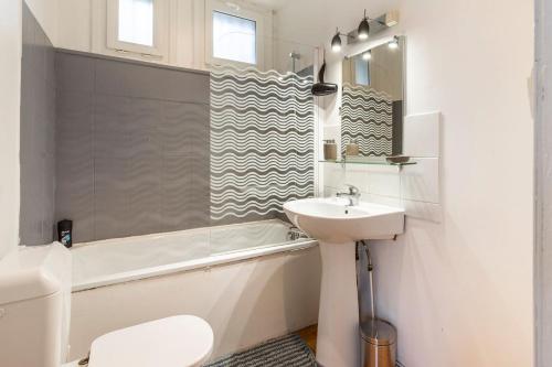 a bathroom with a sink and a toilet and a bath tub at FERY HOME 76 - Au Paradis Caché de Rouen in Notre-Dame-de-Bondeville