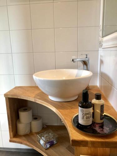 a bathroom with a bowl sink on a wooden shelf at Annehill i Bro in Bro