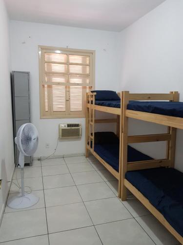 Habitación con 3 literas y ventilador. en Casa Toda, en São Vicente