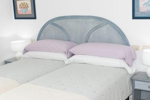 Una cama con tres almohadas encima. en Apartment in South Tenerife with heated pool, en Costa del Silencio