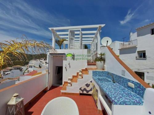 a house with a swimming pool on a balcony at Small village house with beautiful sea views in Torrox