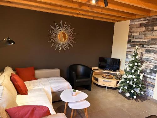 a living room with a christmas tree and a couch at La clairière du lac, le bungalow de l'écureuil in Froid-Chapelle