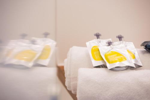 a group of white and yellow detergent bags on towels at All Suites Appart Hôtel - Bordeaux - Mérignac Aéroport in Mérignac