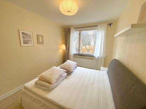 a bedroom with a bed with three pillows on it at Stockholm Apartment Hammarbyhöjden in Stockholm