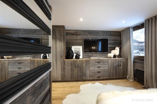 um quarto com painéis de madeira e uma televisão em Studio Megève centre em Megève