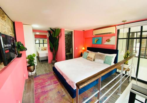 a bedroom with a large bed with red walls at AmazINN Places Casco Viejo Pink Desing and Pool IX in Panama City