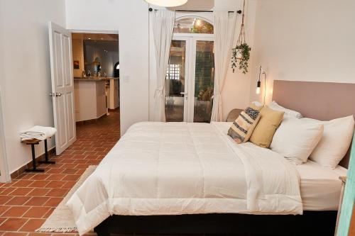 a bedroom with a large bed with white sheets and pillows at AmazINN Places Casco Viejo Casa Espanola in Panama City