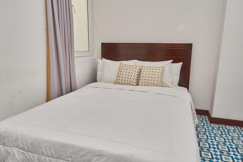 a bed with white sheets and pillows in a room at AmazINN Places Casco Viejo Casa Boyd in Panama City