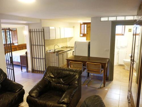sala de estar con sofá, mesa y cocina en La Fioraia bilocale con giardino en LʼAquila