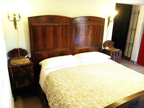 a bedroom with a large wooden bed and two chairs at La Fioraia bilocale con giardino in LʼAquila
