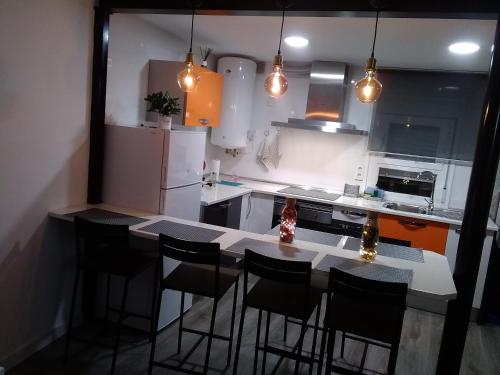 cocina con mesa, sillas y nevera en HOMELY Duplex Curtidores, en Cuenca