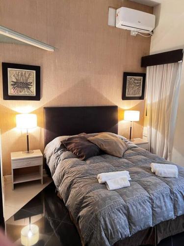 1 dormitorio con 1 cama grande y 2 toallas. en Hermoso loft en zona Recoleta c pileta! en Buenos Aires