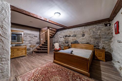 a bedroom with a bed and a stone wall at Roofs of the Old Tallinn Guest House in Tallinn