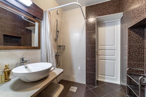 a bathroom with a white sink and a shower at Roofs of the Old Tallinn Guest House in Tallinn