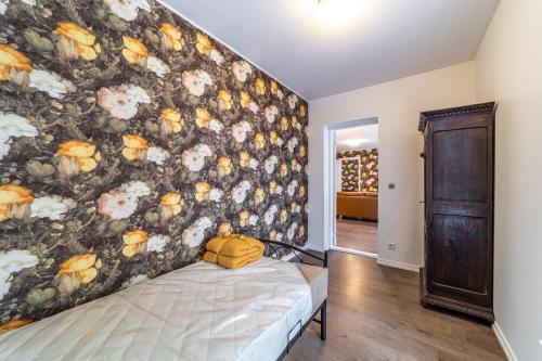 a bedroom with a large floral wall at Roofs of the Old Tallinn Guest House in Tallinn