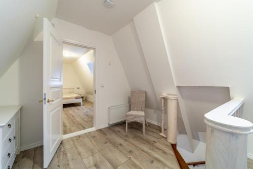 um quarto no sótão com uma escada e uma cadeira em Roofs of the Old Tallinn Guest House em Talin