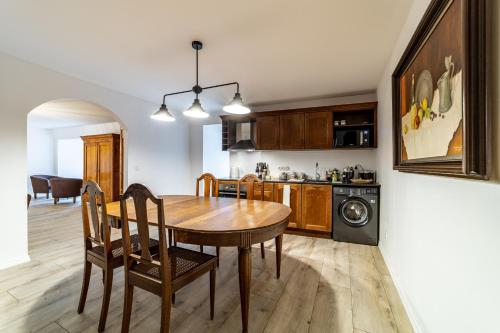 a kitchen and dining room with a wooden table and chairs at Roofs of the Old Tallinn Guest House in Tallinn