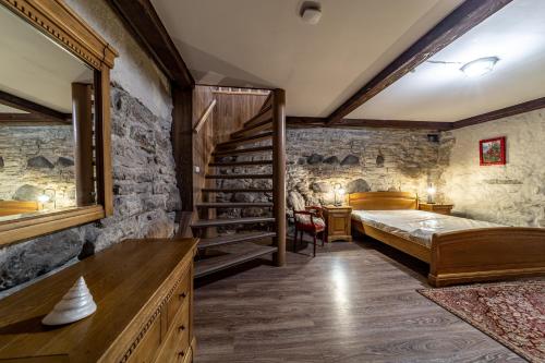 a bedroom with a bed and a stone wall at Roofs of the Old Tallinn Guest House in Tallinn