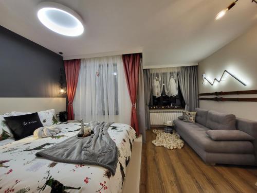 a bedroom with a bed and a couch at Pinewood ANG luxurious apartment A43, Borovets Gardens in Borovets