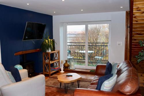 a living room with a couch and a table at Extended Fishermans cottage with stunning sea views in The Mumbles