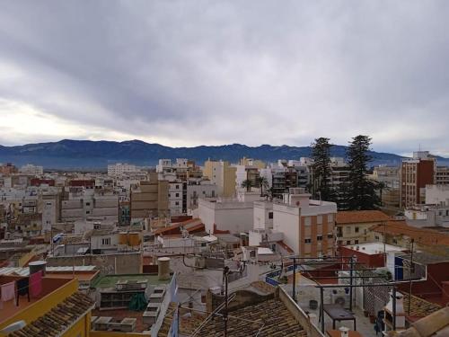 a city with buildings and mountains in the background at Casa Rustica a pie de montaña in Cullera