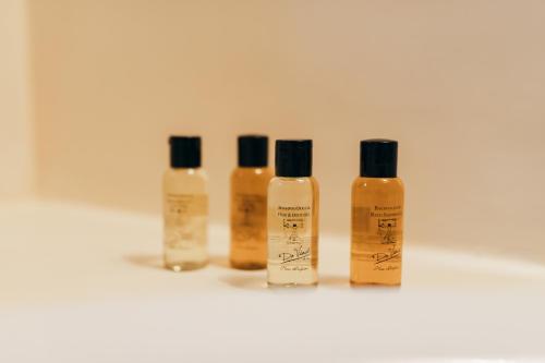 a group of four bottles of moisturizers on a white counter at [Private Parking] centro storico: l'affresco in Bologna