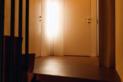an empty room with a door and a wooden floor at [Private Parking] centro storico: l'affresco in Bologna