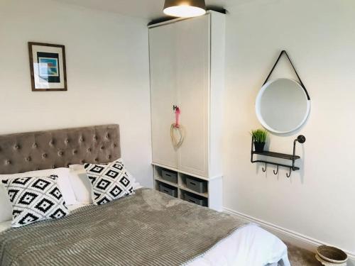 Schlafzimmer mit einem Bett und einem Wandspiegel in der Unterkunft Spacious 3 bed house near beach! in Lowestoft