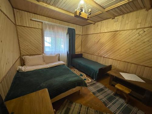 Kleines Zimmer mit einem Bett und einem Fenster in der Unterkunft ЛІСОВА ХАТИНКА in Kelechin