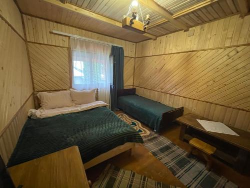 KelechinにあるЛІСОВА ХАТИНКАのベッドと窓が備わる小さな客室です。