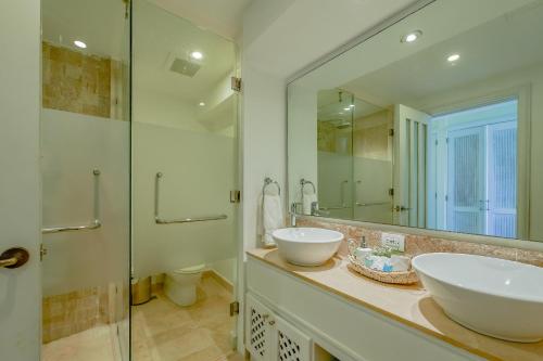 baño con 2 lavabos y espejo grande en Punta Palmera Beach Front 3b apartment Cap Cana en Punta Cana