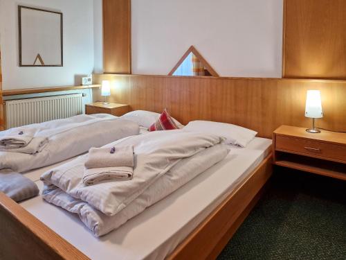 a bedroom with two beds with towels on them at Ferien vom Ich, Bayerischer Wald, Hotel & Restaurant in Neukirchen
